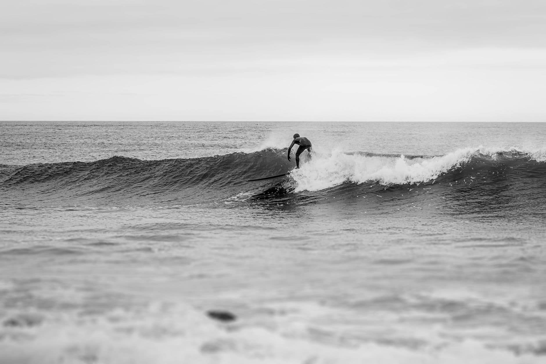 A surfer expertly rides a wave in Uruguay's ocean, capturing the thrill of surf culture.