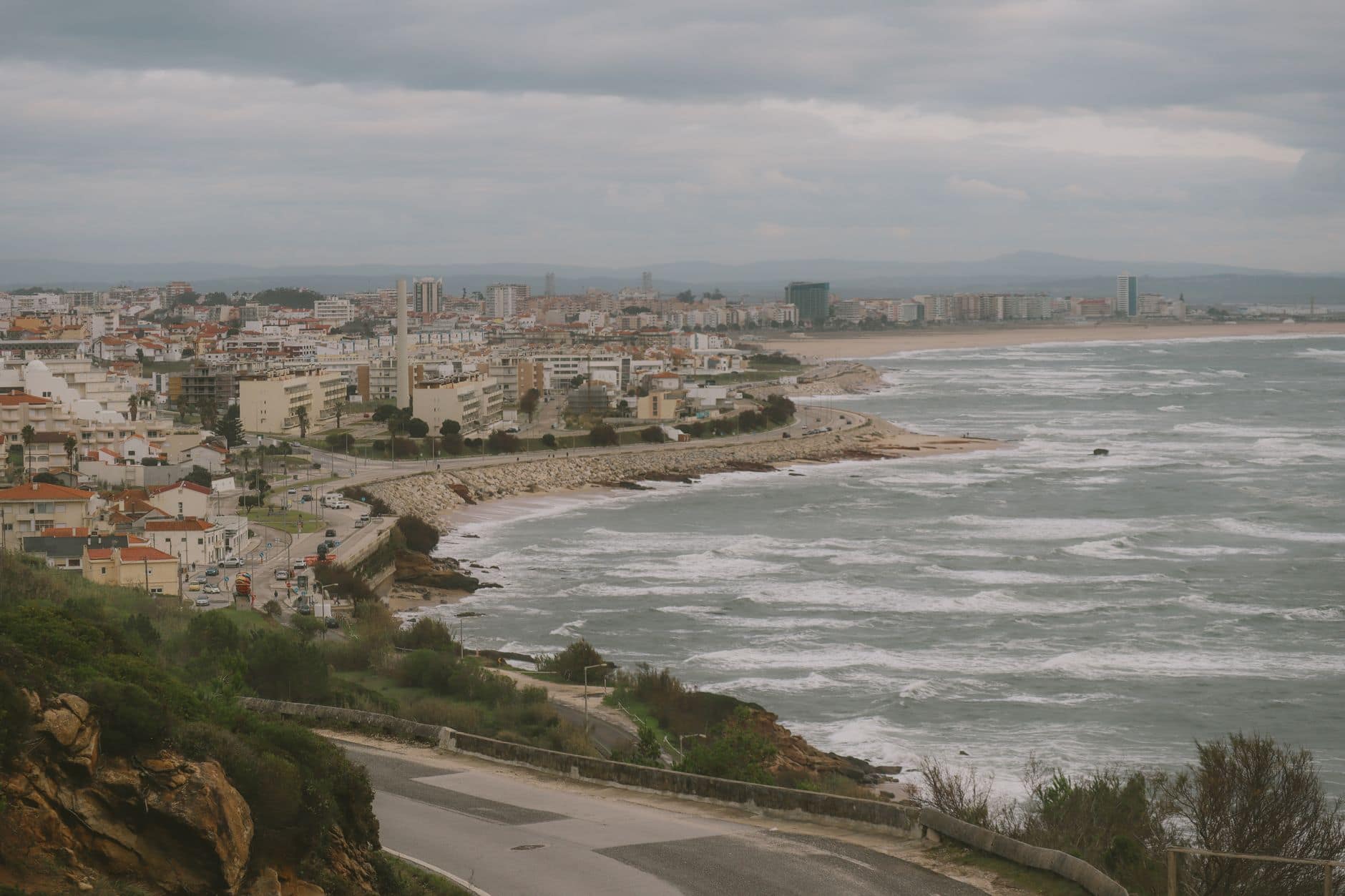 A scenic view of Figueira da Foz city along the Atlantic coast with waves crashing on the shoreline.