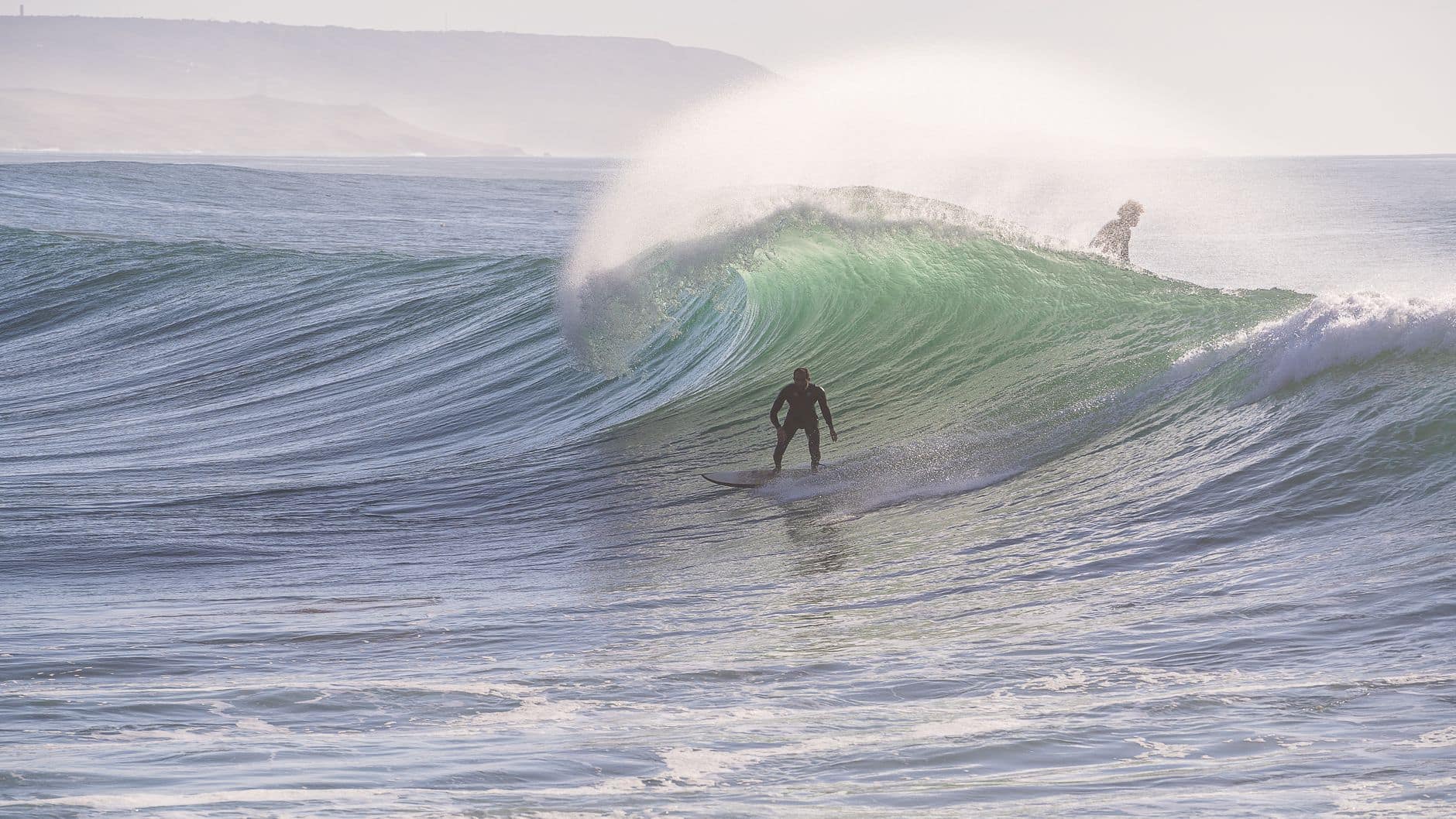Surfers riding impressive waves at Imsouane, Morocco, capturing a thrilling water sport moment.