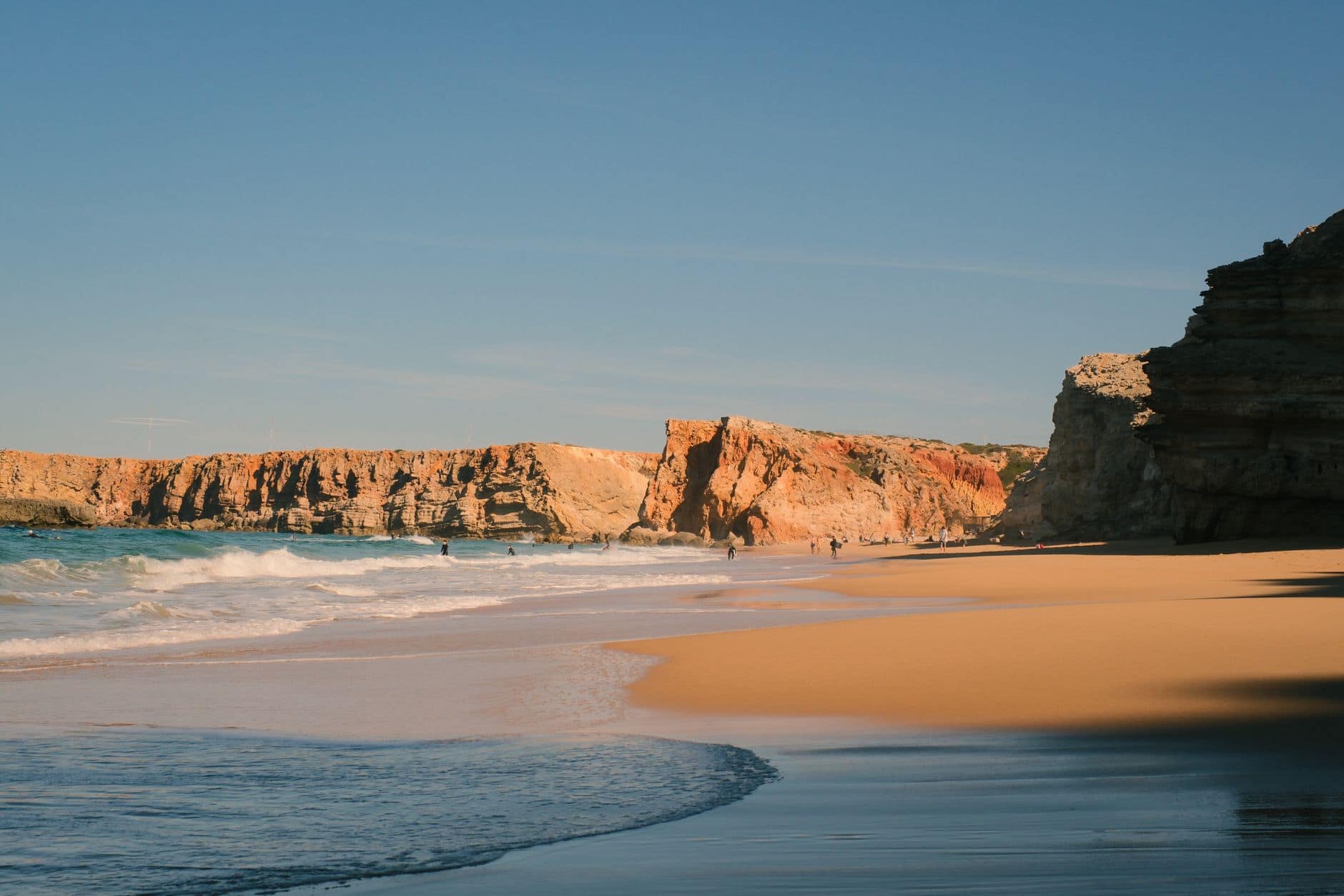 Breathtaking view of Tonel Beach cliffs at sunrise in Sagres, Portugal, with golden sands and serene waves.